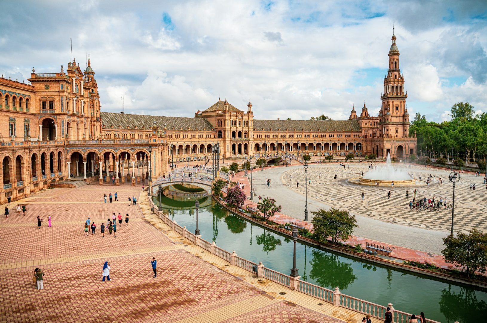 A view of an expansive square, bordered by historic architecture and a body of water